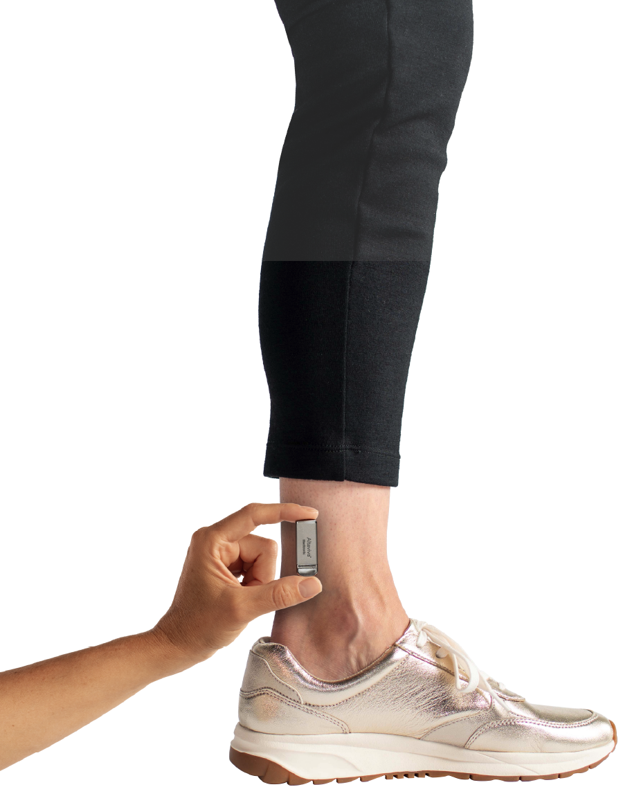 Altaviva device held by a hand in front of an adult human ankle
